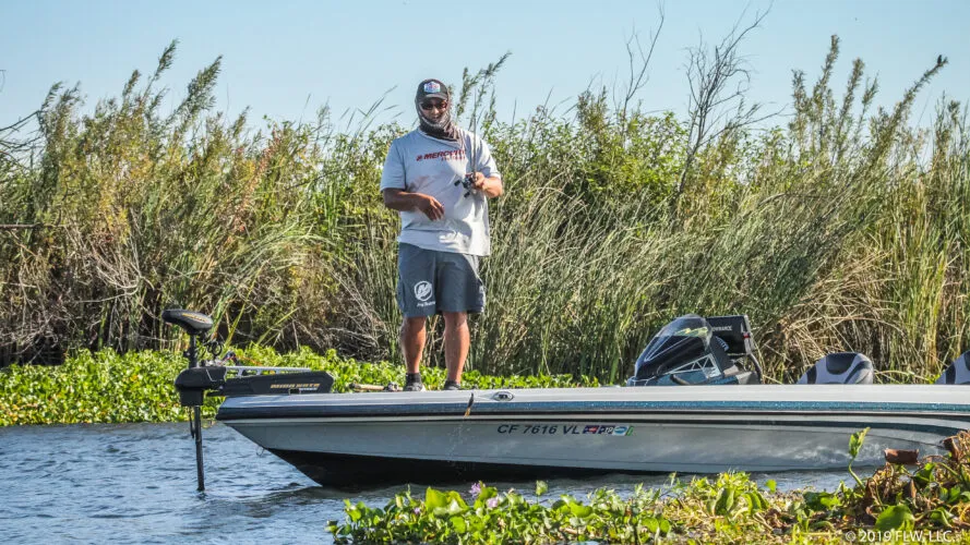 An angler flipping a jig into heavy matted vegetation on the California Delta.
